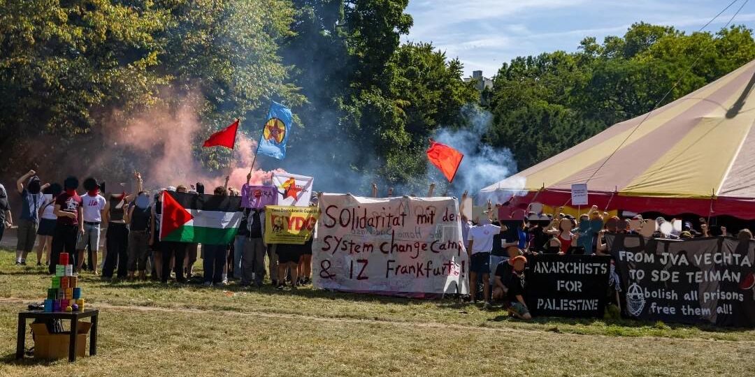 Solidaritätsfoto des Rheinmetall Entwaffnen Camps mit dem IZ in Frankfurt, das von einem Brandanschlag und einer Räumung durch die Stadt bedroht ist.